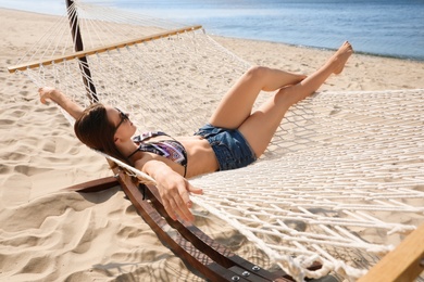 Young woman relaxing in hammock on beach