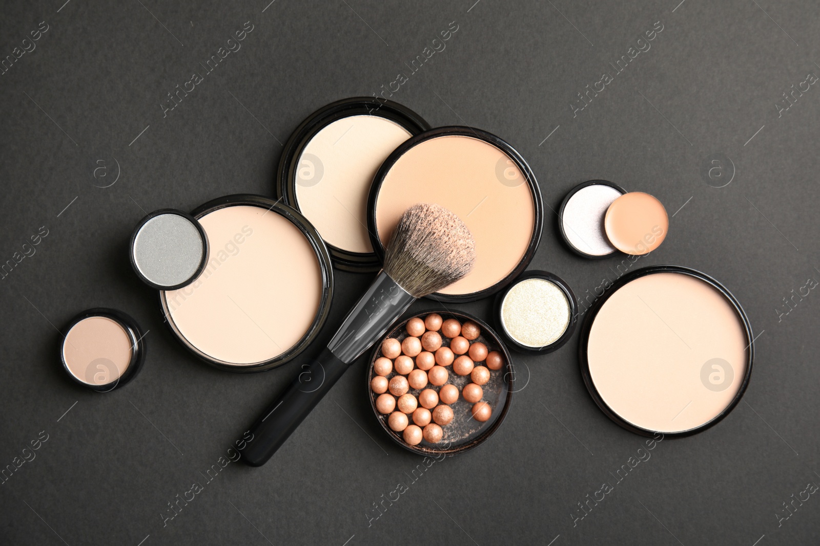 Photo of Flat lay composition with various makeup face powders on black background