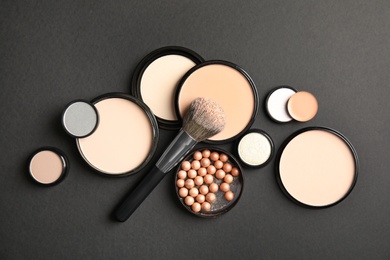 Flat lay composition with various makeup face powders on black background