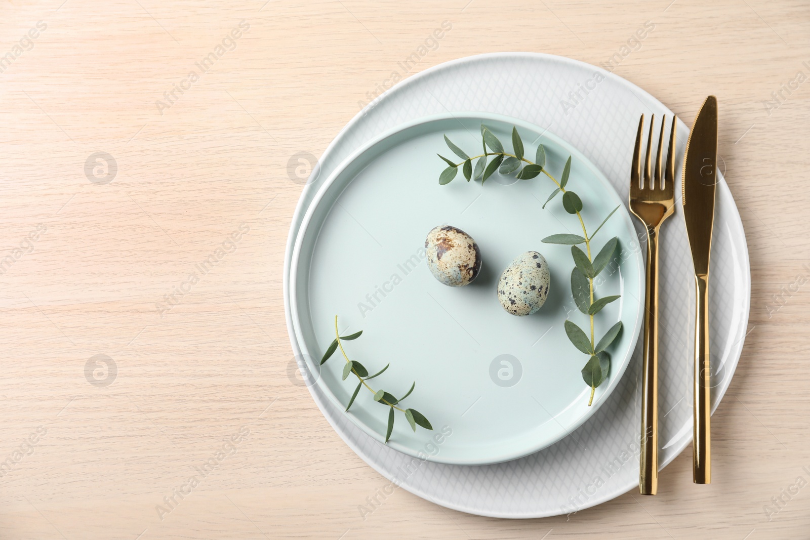Photo of Festive Easter table setting with quail eggs on wooden background, flat lay.