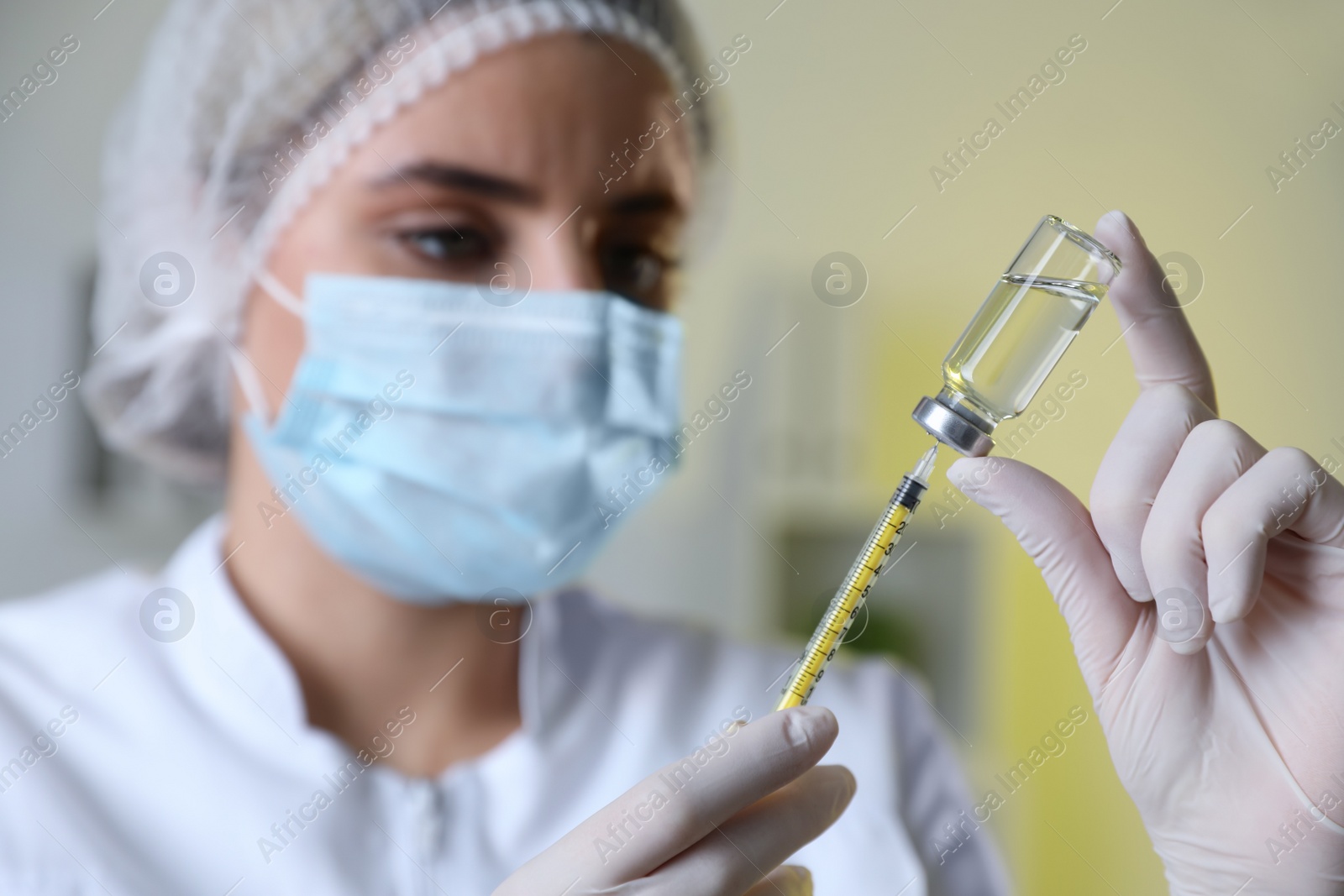 Photo of Doctor filling syringe with medication in clinic, focus on hands. Vaccination and immunization