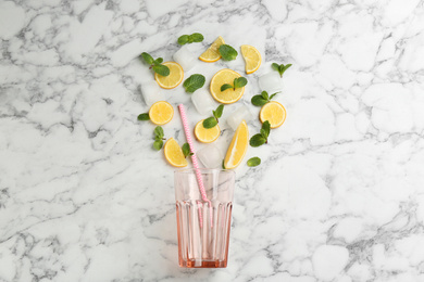 Photo of Creative lemonade layout with lemon slices, mint and ice on white marble table, top view