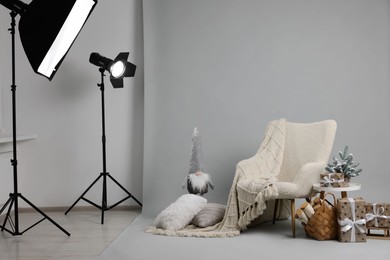 Stylish photo zone with armchair and Christmas decor in professional studio