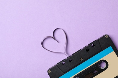 Photo of Top view of music cassette and heart made with tape on violet background, space for text. Listening love song