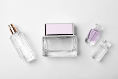 Photo of Transparent bottles of perfume on white background