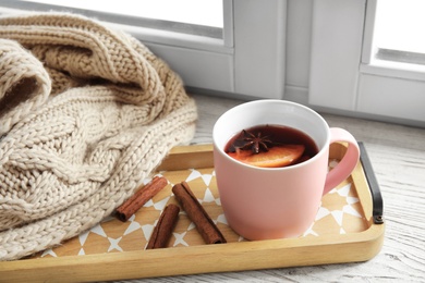 Composition with cup of hot winter drink on sill near window. Cozy season