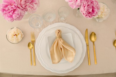 Stylish table setting with beautiful peonies and fabric napkin, flat lay