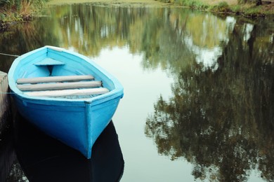 Photo of Light blue wooden boat on lake, space for text