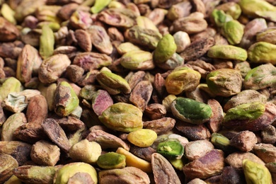 Photo of Shelled organic pistachio nuts as background, closeup