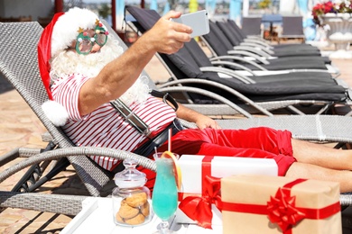 Photo of Authentic Santa Claus taking selfie at resort