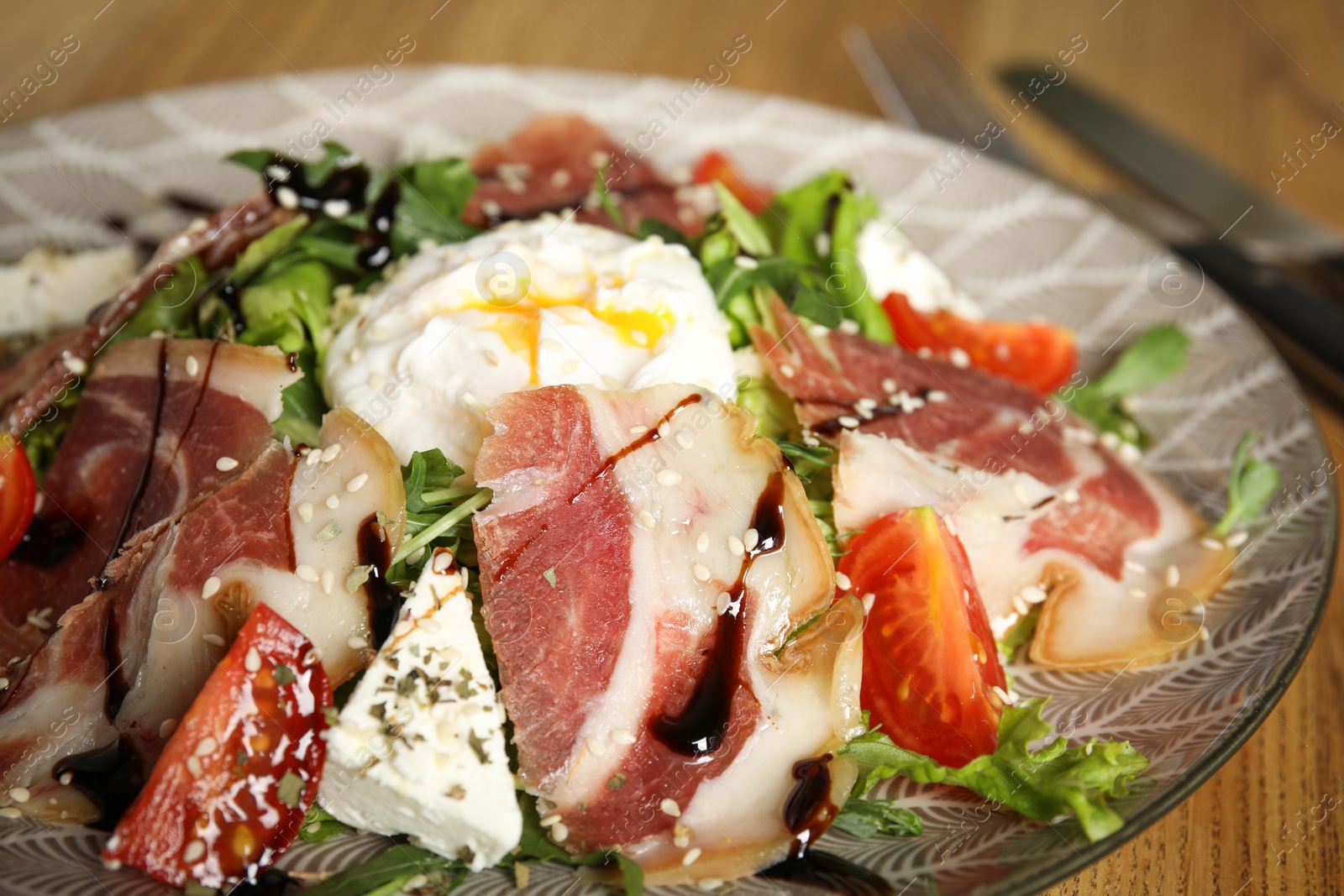 Photo of Delicious prosciutto salad with vegetables on plate, closeup