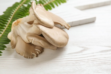 Delicious organic oyster mushrooms on wooden table, space for text