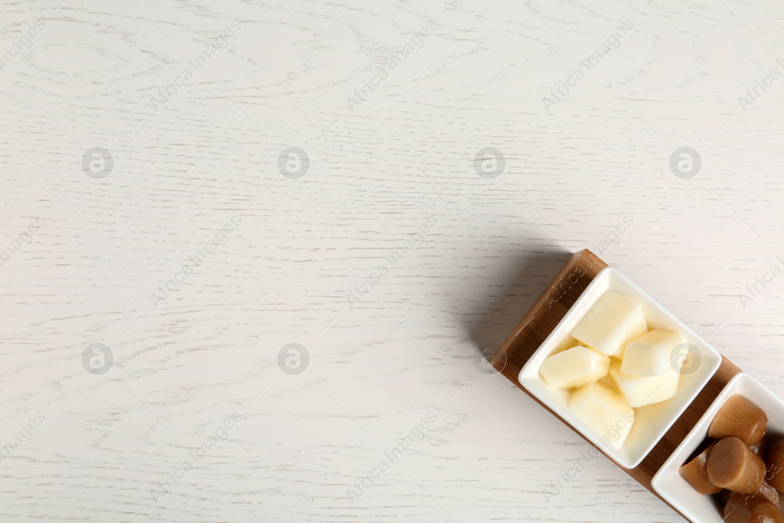 Photo of Flat lay composition with milk and coffee ice cubes on white wooden background. Space for text