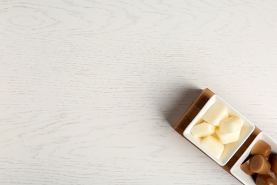 Flat lay composition with milk and coffee ice cubes on white wooden background. Space for text