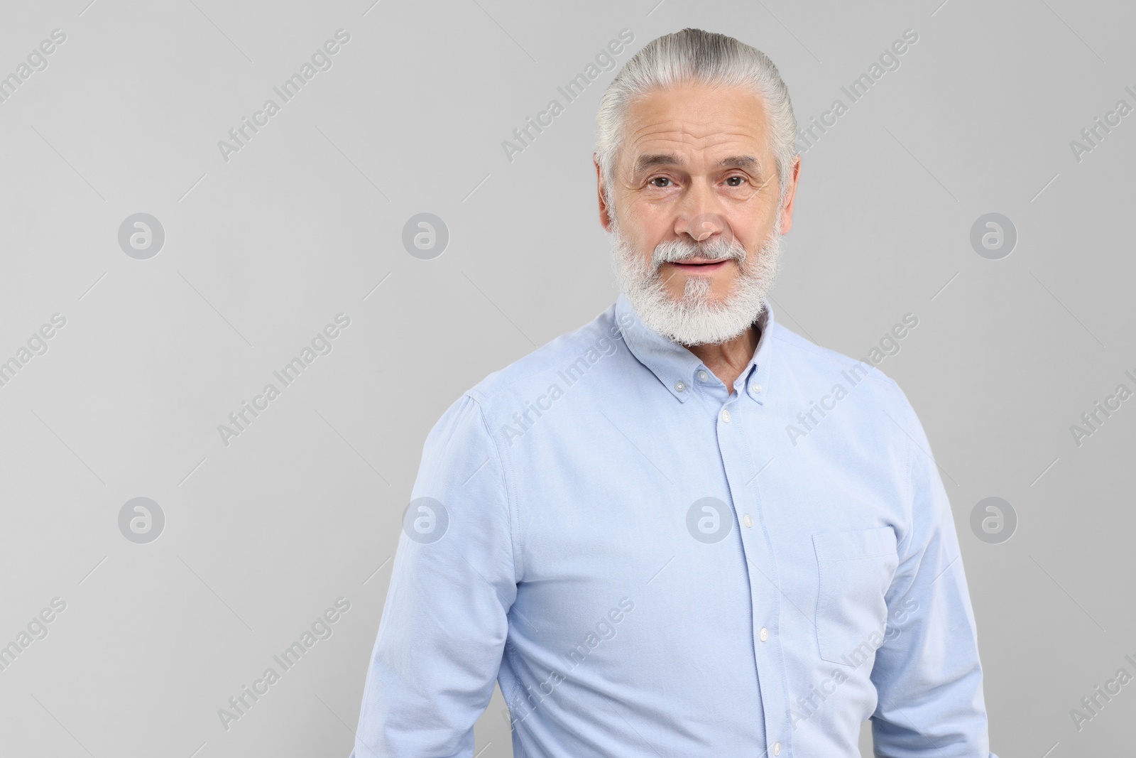 Photo of Portrait of handsome senior man on light grey background. Space for text