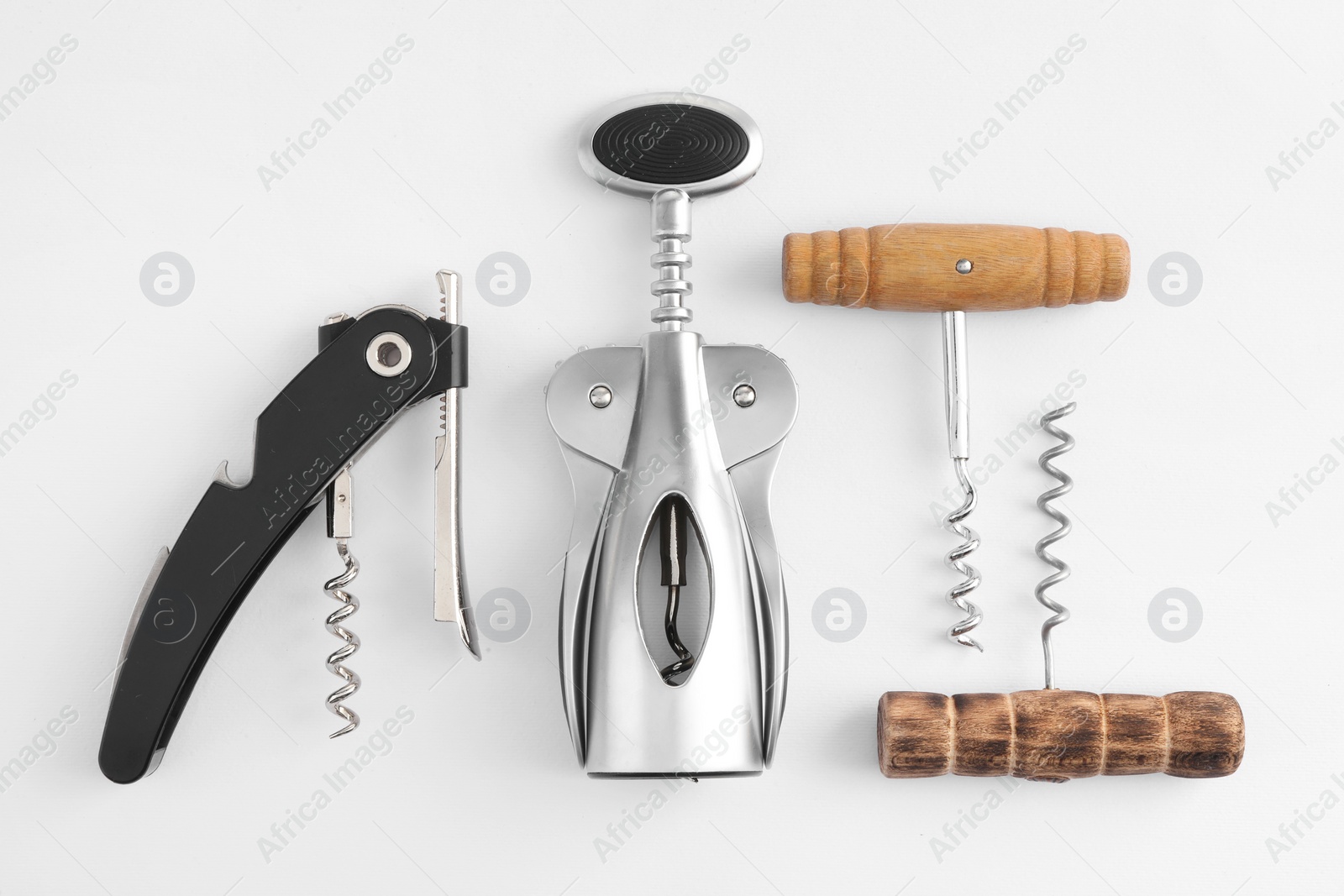 Photo of Different corkscrews on white background, flat lay