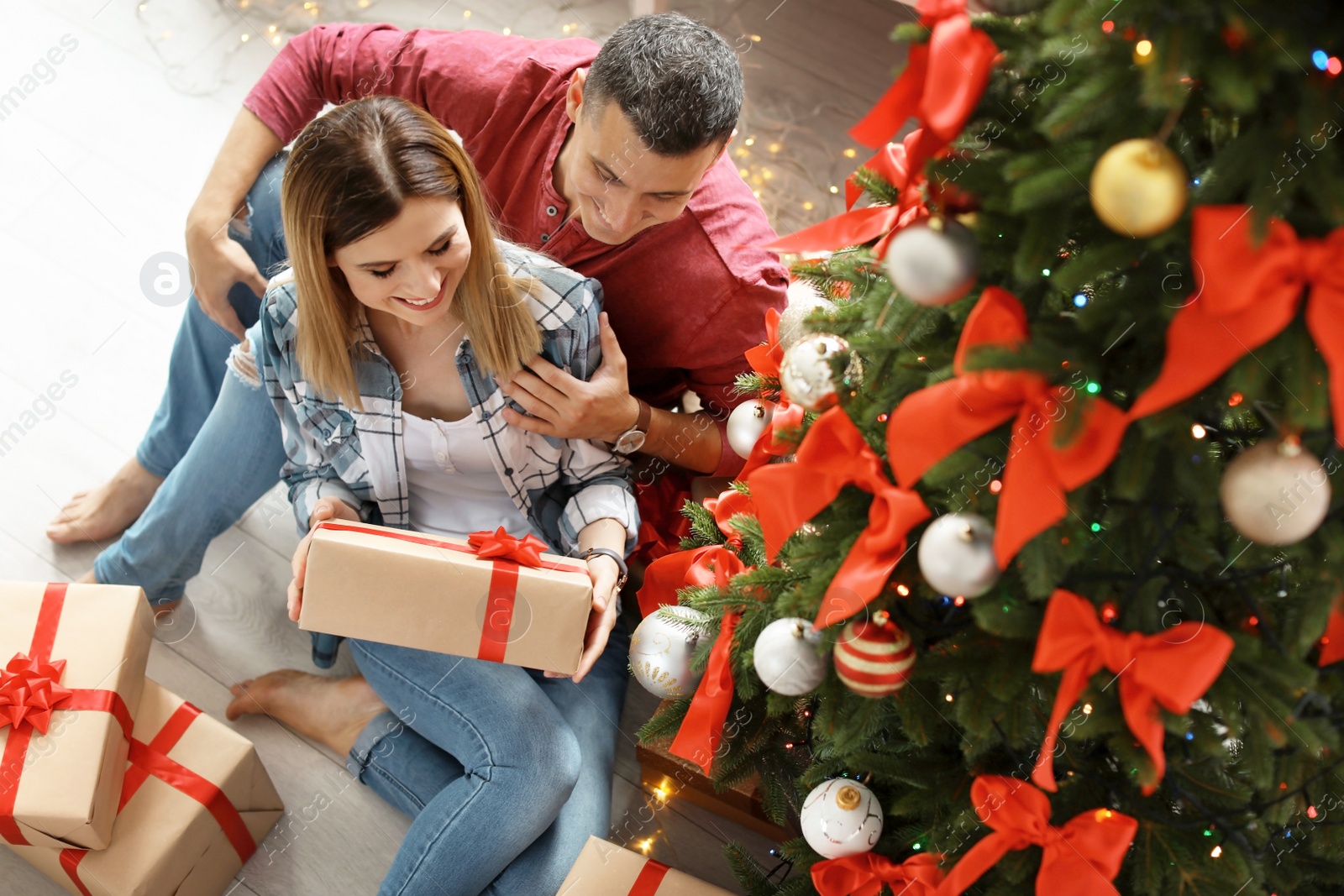 Photo of Young couple with Christmas gifts at home