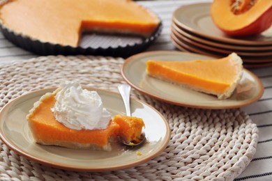 Photo of Fresh homemade pumpkin pie with whipped cream on table