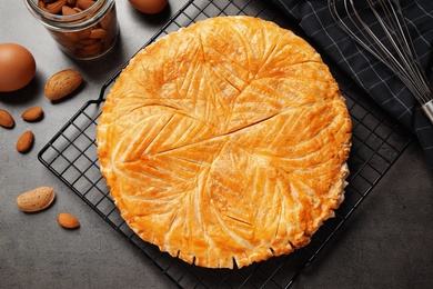 Photo of Traditional galette des rois and ingredients on grey table, flat lay