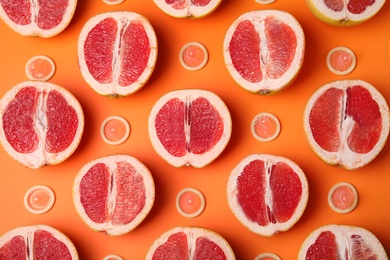 Photo of Flat lay composition with condoms and grapefruits on orange background. Erotic concept