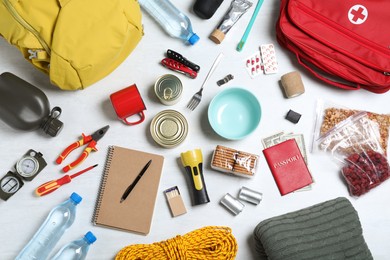 Photo of Disaster supply kit for earthquake on white wooden table, flat lay