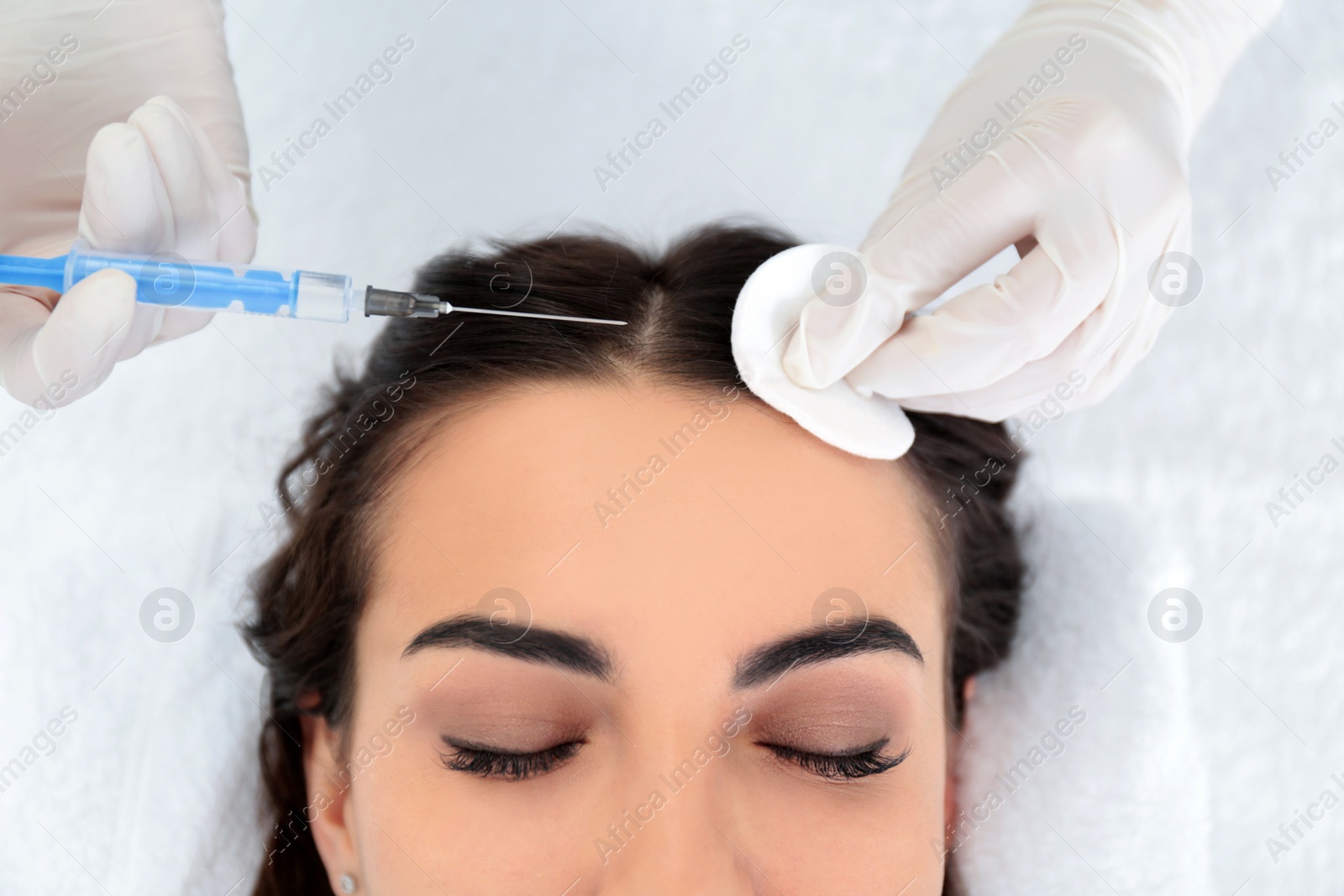 Photo of Young woman with hair loss problem receiving injection in salon, closeup