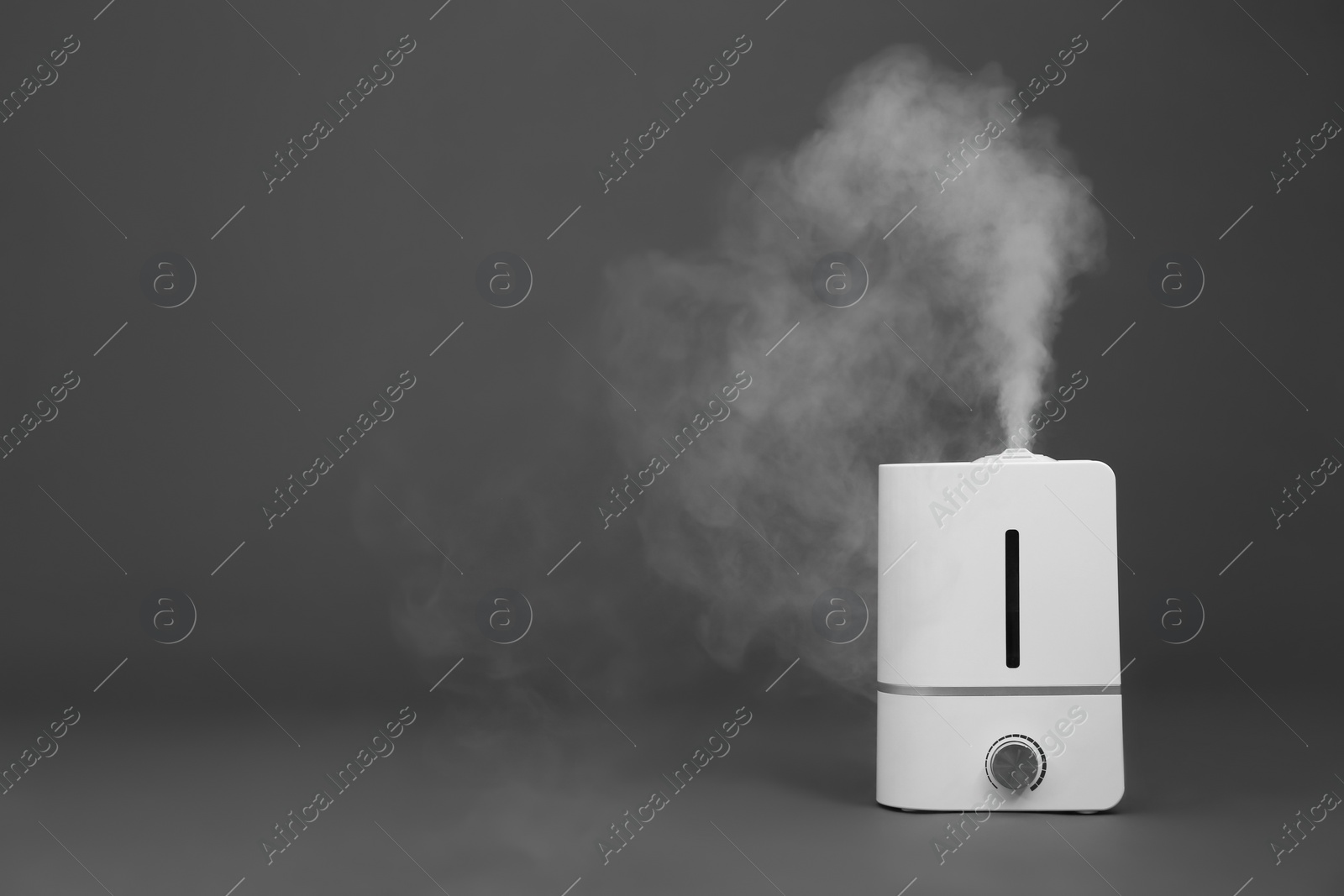 Photo of Modern air humidifier on grey background. Space for text