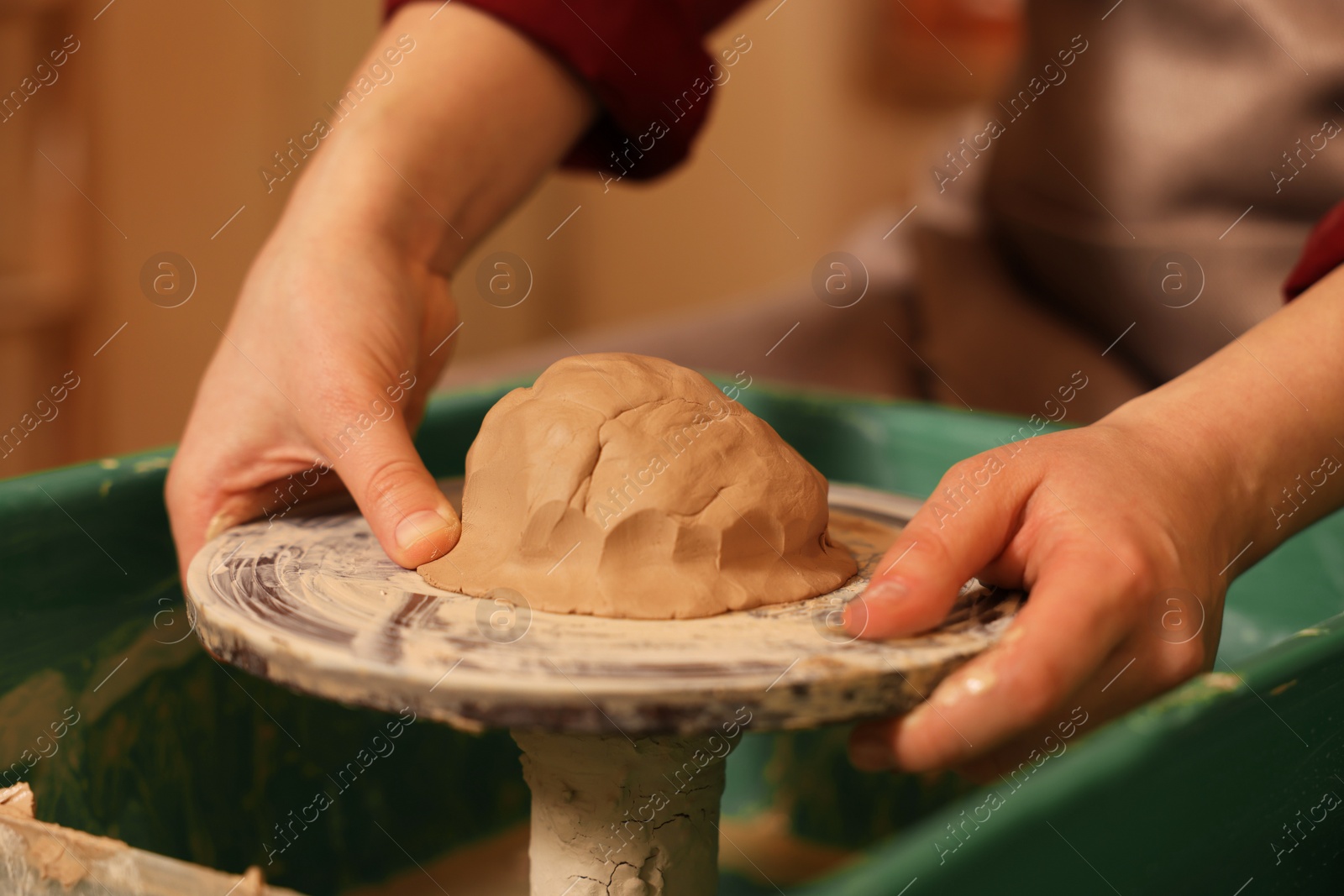 Photo of Woman crafting with clay on potter's wheel, closeup