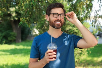 Photo of Handsome man with delicious juice in park