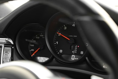 Photo of Speedometer and tachometer inside of modern car, closeup