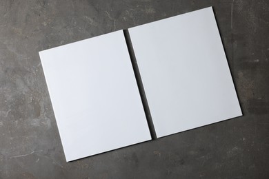 Photo of Blank paper sheets on grey textured background, top view. Mockup for design