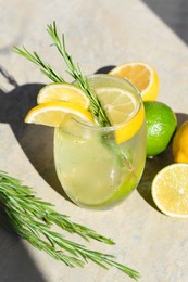Photo of Tasty refreshing lemonade and ingredients on light table. Summer drink
