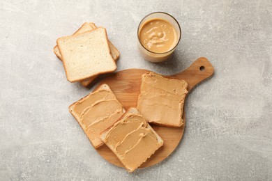 Photo of Tasty peanut butter sandwiches on gray table, flat lay