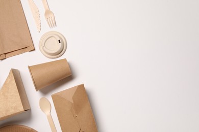 Photo of Eco friendly food packaging. Paper containers, bag and tableware on white background, flat lay. Space for text