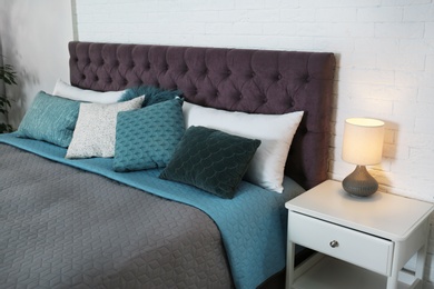 Photo of Large comfortable bed near light wall in modern room interior