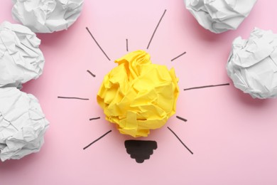 Photo of Composition with crumpled paper ball as lamp bulb on pink background, flat lay. Idea concept