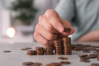 Photo of Man stacking coins at table indoors, closeup