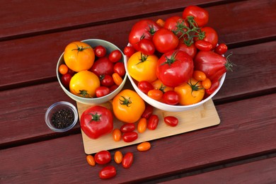 Photo of Bowls with fresh tomatoes and spices on wooden table, flat lay