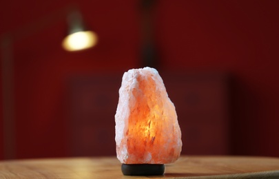 Photo of Himalayan salt lamp on table at home