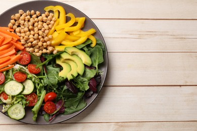 Photo of Balanced diet and vegetarian foods. Plate with different delicious products on wooden table, top view. Space for text