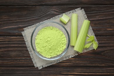 Photo of Natural celery powder in bowl and fresh stalks on wooden table, top view