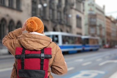 Image of Traveler with backpack in foreign city during vacation, back view