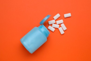 Jar with chewing gums on orange background, flat lay