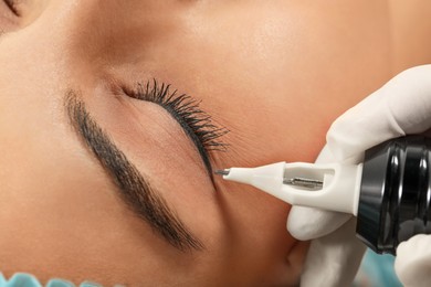 Young woman undergoing procedure of permanent eyeliner makeup, closeup