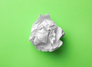Photo of Crumpled sheet of paper on color background, top view