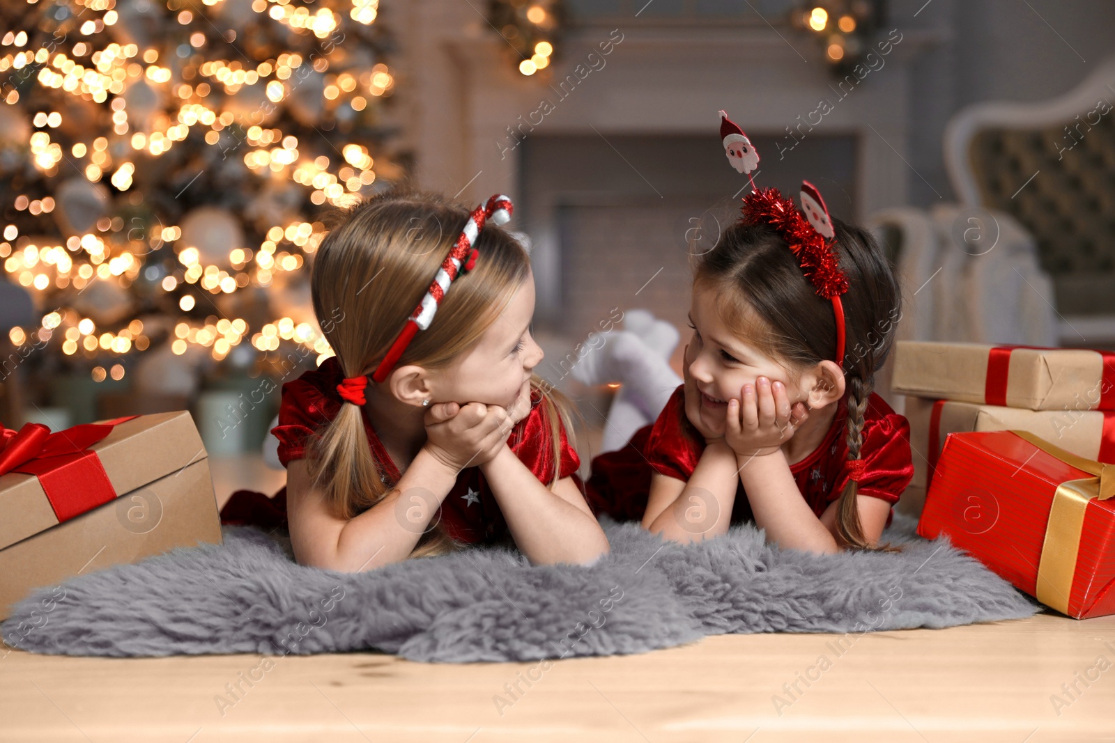 Photo of Cute little children with Christmas gifts at home
