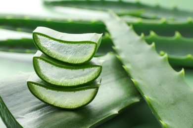 Photo of Fresh aloe vera pieces on green background, closeup