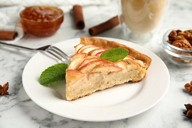 Photo of Slice of delicious apple pie on white marble table