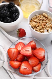 Photo of Fresh berries and tasty oatmeal on white tiled table, closeup. Healthy breakfast
