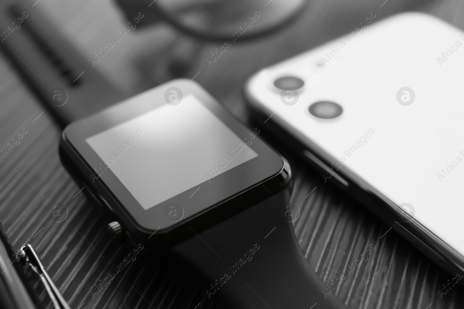 Stylish smart watch and phone on black table, closeup Photo of Stylish smart watch and phone on black table, closeup